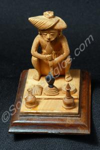 Carved wooden figure of an Indian snake charmer on
