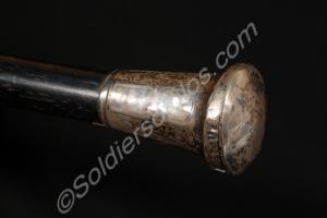 Black cane with a silver head and brass tip. Made