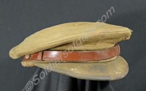 Khaki forage cap with no buttons and bullet holes.