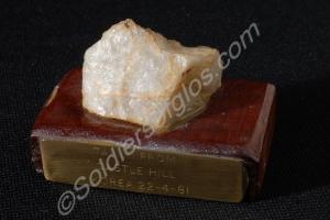 Piece of rock on wooden block, taken from Castle H