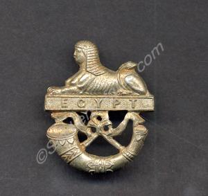 White metal badge depicting a sphinx with post hor
