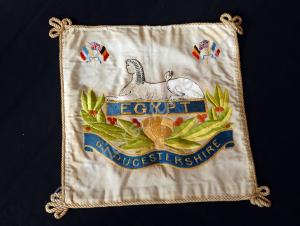 White embroidered cushion cover with front badge a