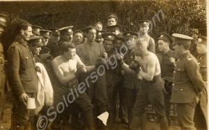 Group of soldiers watching informal boxing match.