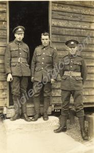 Three soldiers outside wooden hut. Gloucestershire
