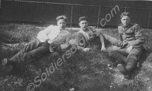 Three soldiers lying on grassy slope. 1st Battalio