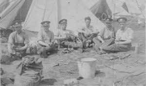 Five soldiers cleaning equipment in camp. 1st Batt