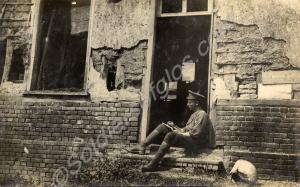 Soldier sitting in doorway writing a letter.  1/4t