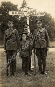 Group of four soldiers standing beneath a signpost