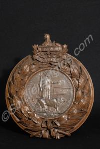 Bronze memorial plaque. Set into a carved oak fram
