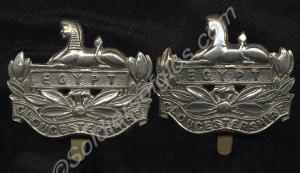 Two white metal Front Badges. Property of 5181698