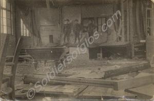 Three soldiers in a wrecked building with a billia