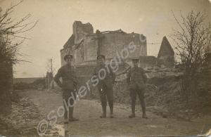 Three soldiers standing in front of a ruined churc