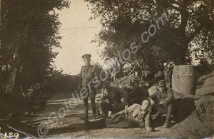 Soldiers resting by a roadside edged by trees.  1/