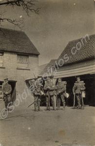 Five soldiers in marching order standing by some b