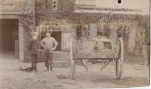 Two men standing outside a building. Includes a ca