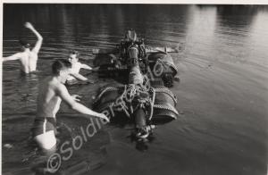 Three soldiers in water with oildrum raft. 1st Bat