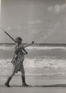 Private Wade of "D" Company patrolling the beach.