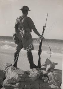 Soldier standing at ease  on the beach.  2nd Batta