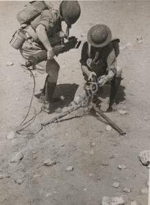 Soldiers in gas masks assembling Vickers machine g