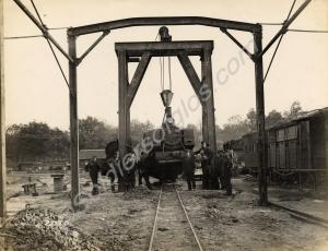 Narrow gauge locomotive hoisted up on crane for re