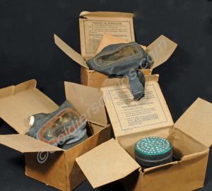 Three Second World War gas masks with boxes.