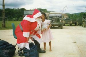 Soldier dressed at Father Christmas with local chi
