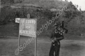 Road sign -  'To Tokyo via Ngayyedauk' with piper.