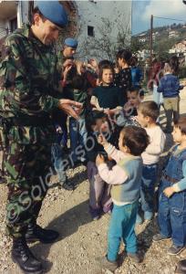 Major Ian Harris handing out sweets to children. R