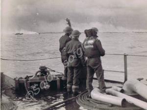 British troops watch smoke rising from battered en