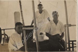 Sergeant Savage, flanked by two others, on board a