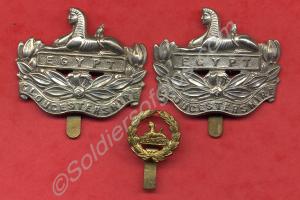 Two white metal front badges, one  brass back badg