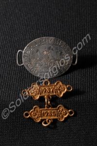 Three badges; One oval bracelet badge engraved '77
