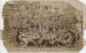 Group of soldiers by wooden huts.  "Gloucestershir