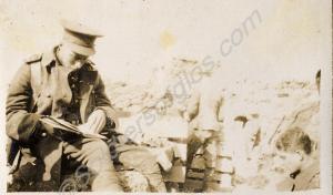 Officer reading on trench parapet. 1st Battalion,
