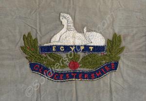 Embroidery of the Gloucestershire Regiment badge.