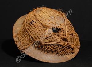 Steel helmet with bullet entry and exit holes. Bel