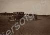 Cars driving along a dirt road.  India c. 1918.