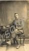 Sergeant sitting on a chair, arm resting on table.