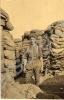 Soldier standing in front of sandbags. "Daily scen