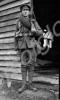 Soldier standing outside hut. 12th Battalion, The